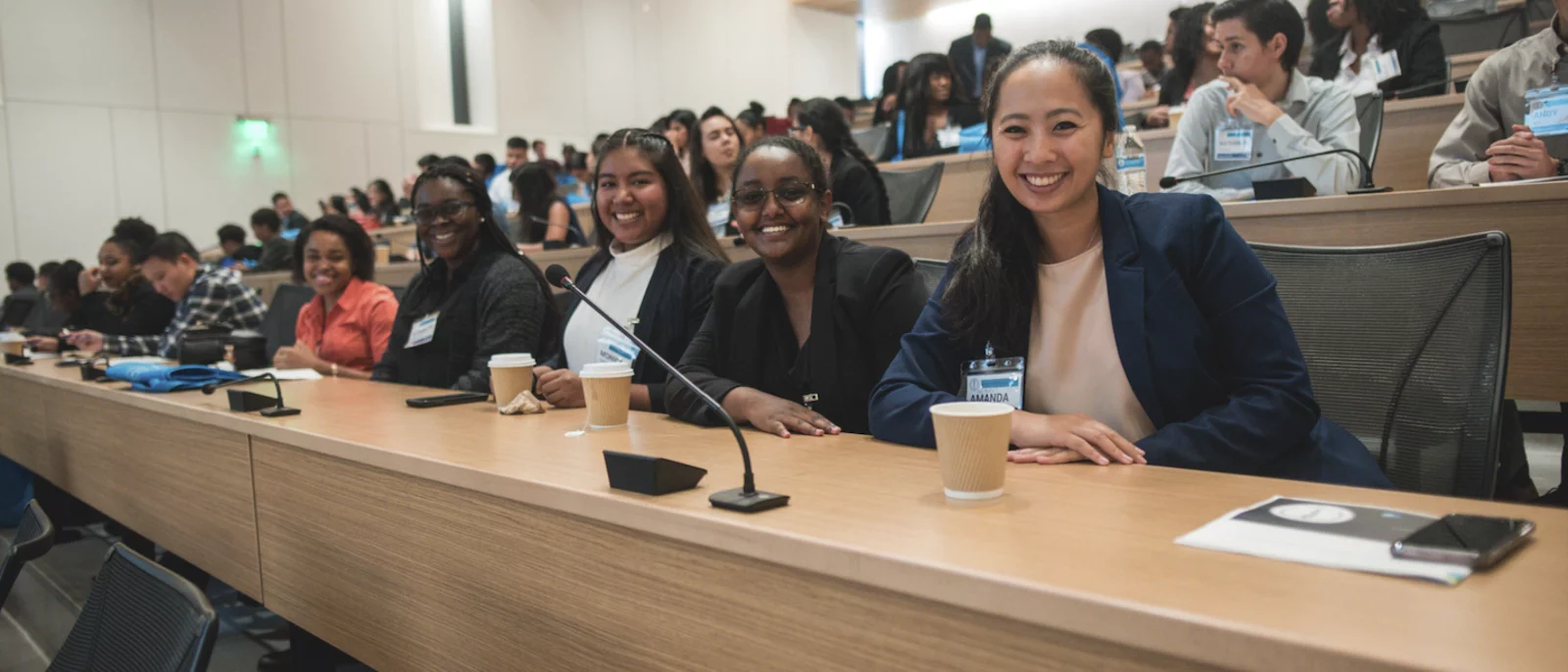 Medical students in a lecture in Geffen Hall smiling at the camera