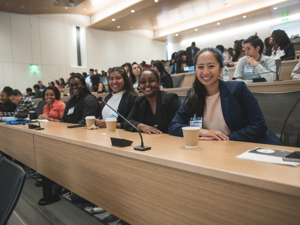 Medical students in a lecture in Geffen Hall smiling at the camera